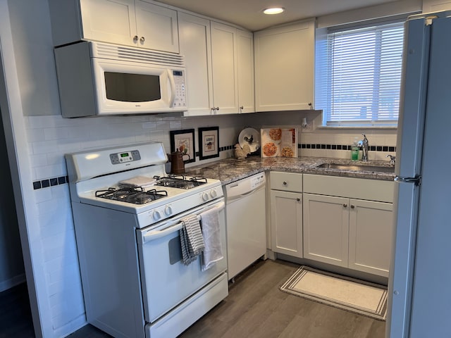 kitchen featuring white appliances, a sink, dark wood-type flooring, white cabinets, and tasteful backsplash