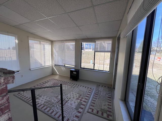 unfurnished sunroom featuring a drop ceiling and plenty of natural light