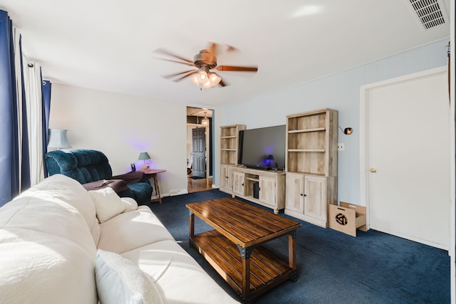 living room with dark colored carpet, visible vents, and a ceiling fan