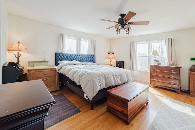 bedroom with multiple windows, a ceiling fan, and light wood finished floors