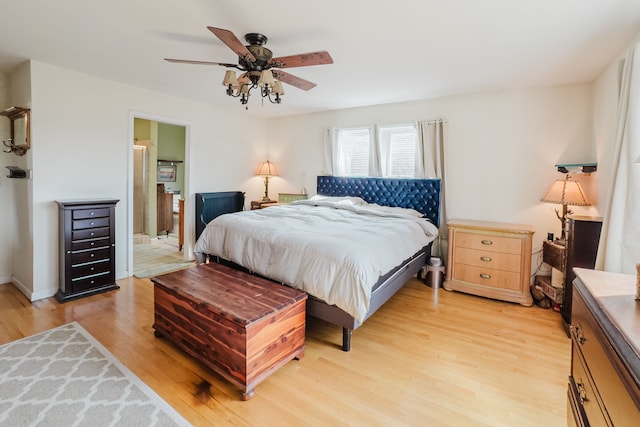 bedroom featuring light wood-type flooring, ceiling fan, and ensuite bathroom