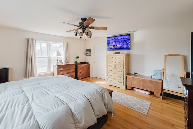 bedroom featuring visible vents, light wood finished floors, and ceiling fan