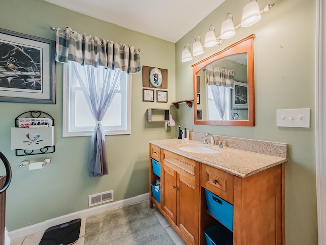 bathroom with visible vents, a healthy amount of sunlight, vanity, and baseboards