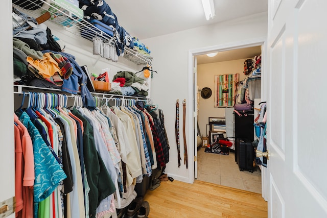 walk in closet with wood finished floors