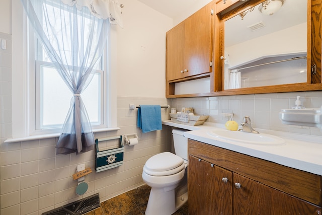 bathroom featuring vanity, toilet, a healthy amount of sunlight, and visible vents