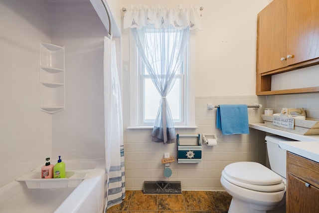 full bath featuring a healthy amount of sunlight, vanity, toilet, and tile walls