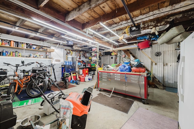 garage featuring freestanding refrigerator, a workshop area, and a garage door opener