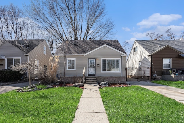 bungalow featuring a front yard, driveway, and a gate