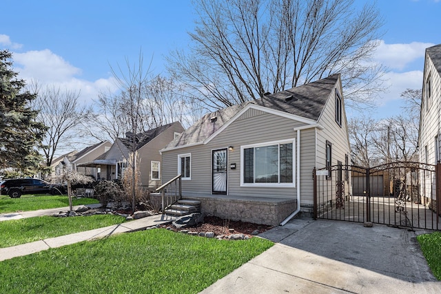 bungalow featuring a front lawn and a gate