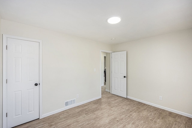 spare room featuring visible vents, baseboards, and light wood-style flooring