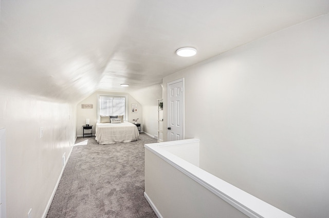 bedroom with lofted ceiling, baseboards, and carpet floors