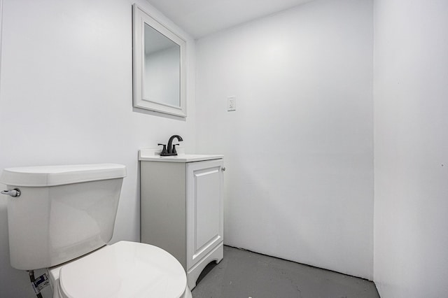 bathroom with toilet, finished concrete floors, and vanity