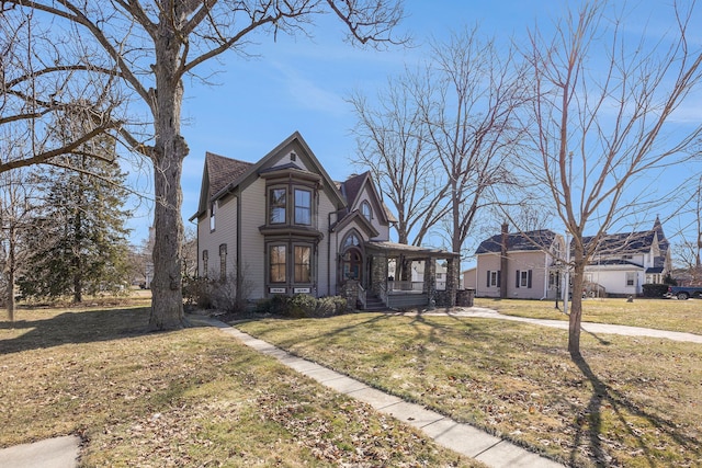 victorian home with a front lawn