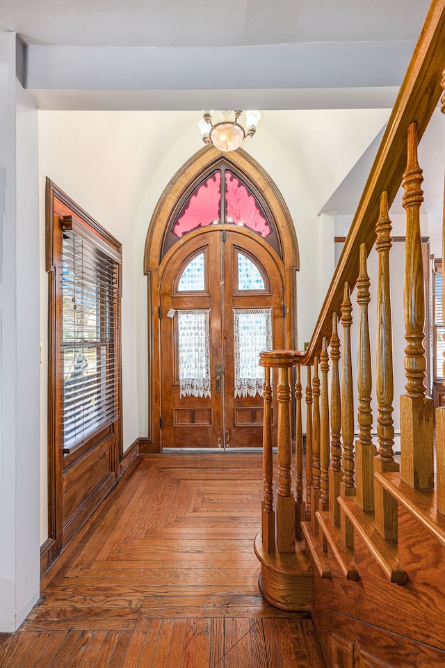 foyer featuring a chandelier, stairway, plenty of natural light, and french doors