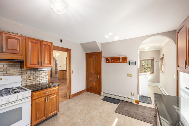 kitchen with a baseboard radiator, white range with gas stovetop, arched walkways, dark countertops, and tasteful backsplash