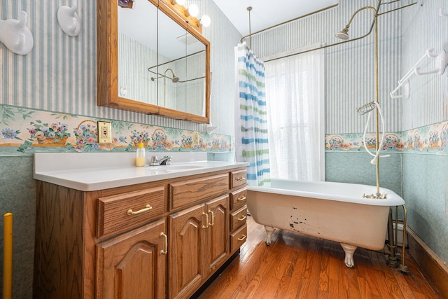 bathroom featuring wallpapered walls, wood finished floors, shower / bath combination with curtain, and vanity