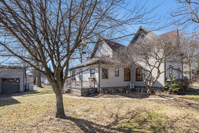 view of side of property featuring a lawn and a deck