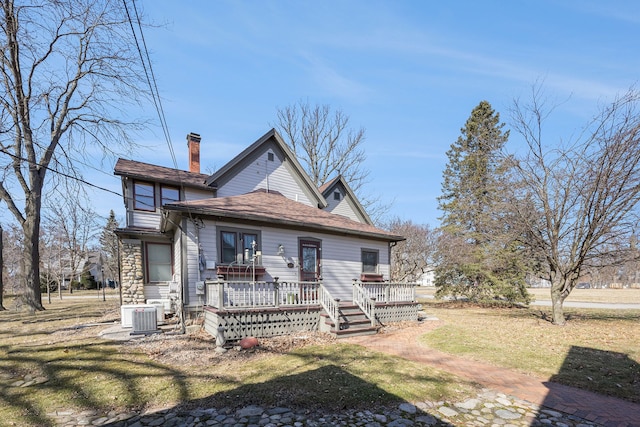 back of property featuring a yard, a chimney, central AC, and a wooden deck