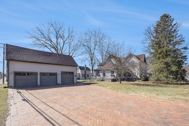 exterior space featuring decorative driveway and a garage