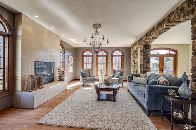 living room featuring a healthy amount of sunlight, a fireplace, and light wood-style floors