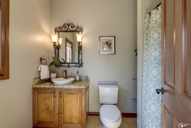 bathroom featuring tile patterned flooring, toilet, vanity, and baseboards