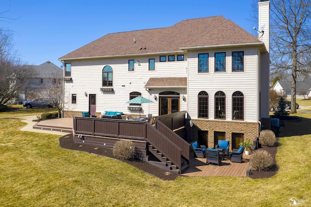 back of property featuring brick siding, a wooden deck, an outdoor hangout area, a chimney, and a yard