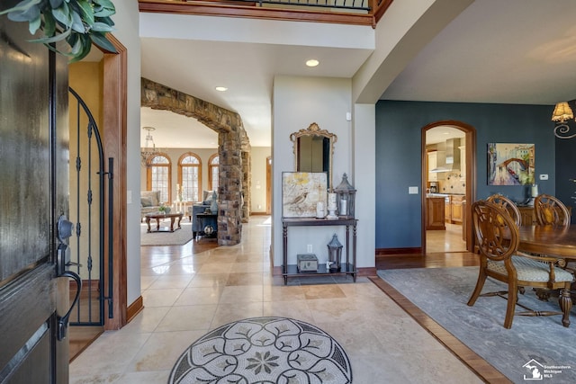 foyer with recessed lighting, light tile patterned flooring, baseboards, and arched walkways