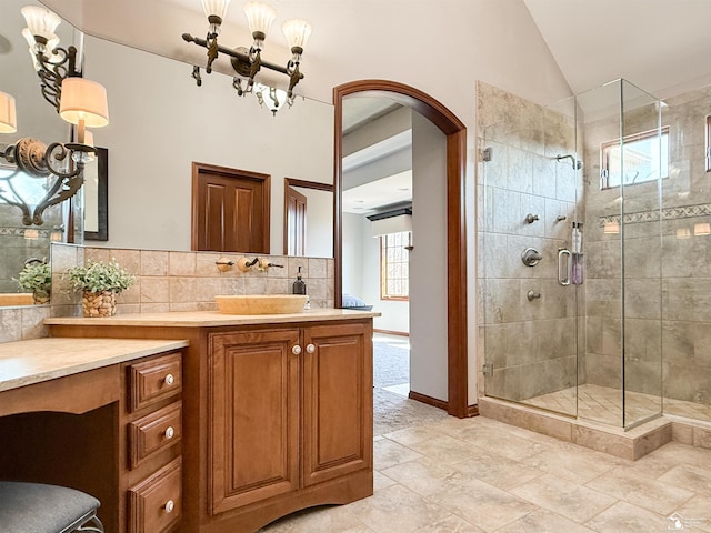 full bathroom featuring tasteful backsplash, a shower stall, vanity, and lofted ceiling