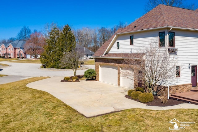 view of home's exterior featuring concrete driveway, a yard, and an attached garage