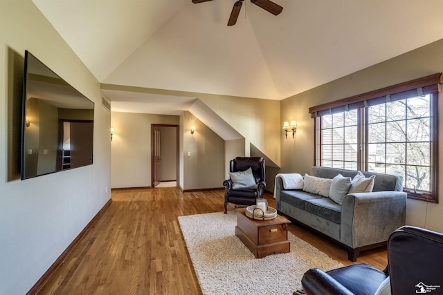 living room featuring wood finished floors, visible vents, baseboards, high vaulted ceiling, and ceiling fan