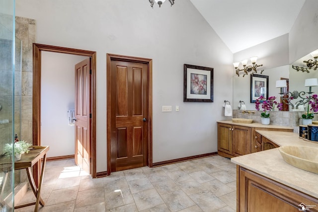 full bathroom featuring a chandelier, vanity, baseboards, and vaulted ceiling