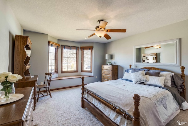 bedroom featuring baseboards, light colored carpet, a ceiling fan, and a textured ceiling