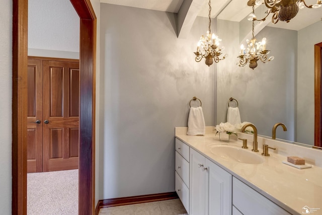 bathroom with tile patterned floors, baseboards, a chandelier, and vanity