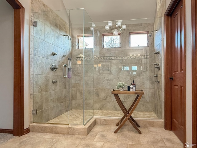 bathroom featuring a shower stall and a chandelier