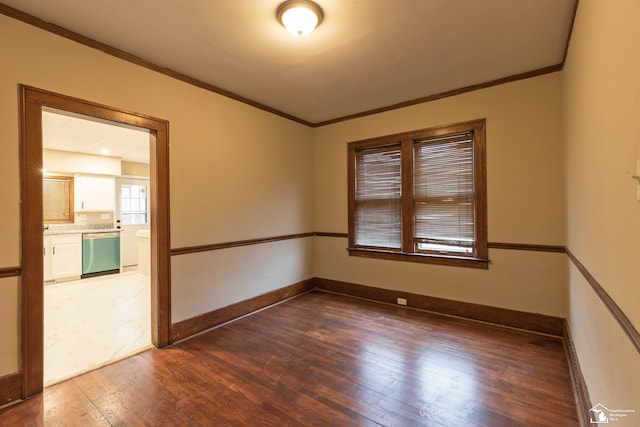 spare room featuring baseboards, wood finished floors, and ornamental molding