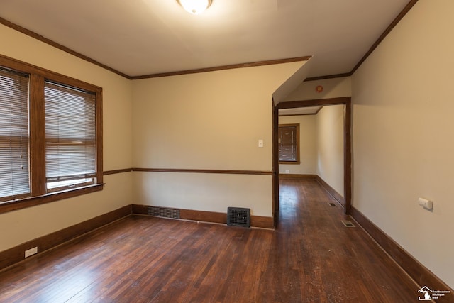 unfurnished room with visible vents, baseboards, wood-type flooring, and ornamental molding