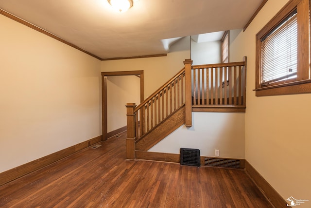 stairway with visible vents, ornamental molding, baseboards, and wood finished floors