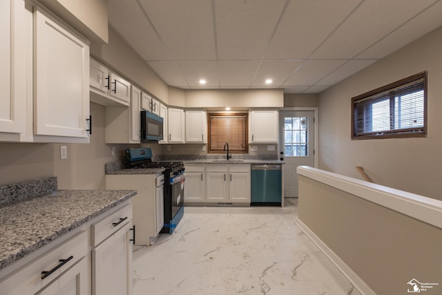 kitchen featuring white cabinetry, a sink, black microwave, dishwasher, and gas range