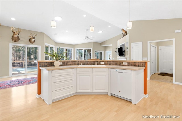 kitchen featuring a ceiling fan, a sink, white cabinetry, white dishwasher, and lofted ceiling