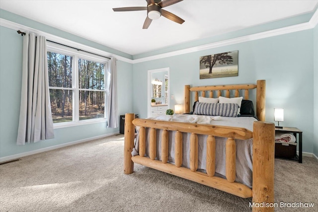 carpeted bedroom with visible vents, ceiling fan, baseboards, and ornamental molding