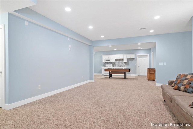 living area with recessed lighting, light colored carpet, visible vents, and baseboards