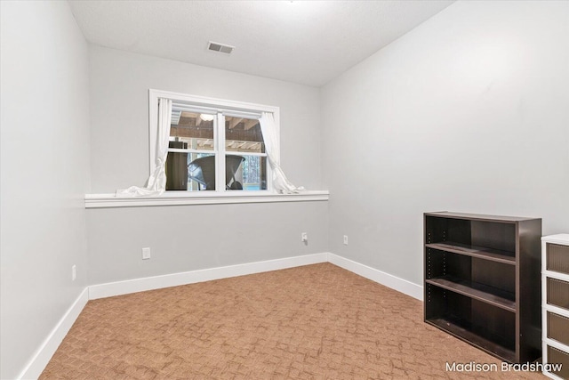 unfurnished room with visible vents, baseboards, and carpet