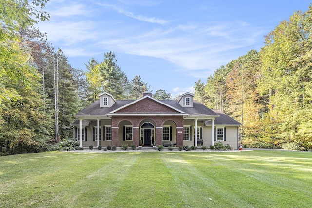 view of front of house with brick siding, a front lawn, and a shingled roof