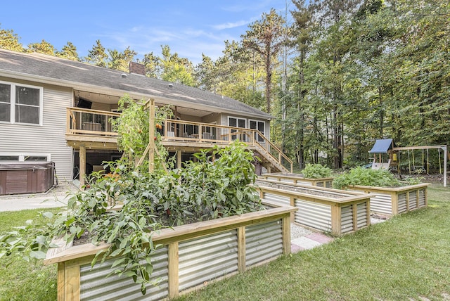 back of house featuring cooling unit, a garden, a chimney, a hot tub, and a lawn