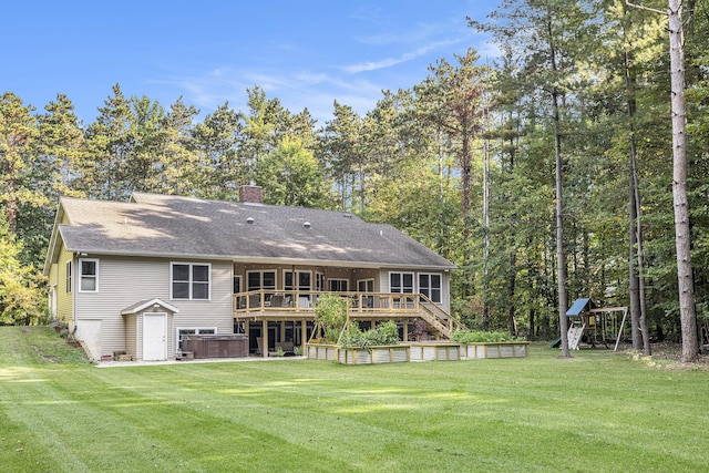 rear view of property with a deck, a yard, stairway, a chimney, and a hot tub