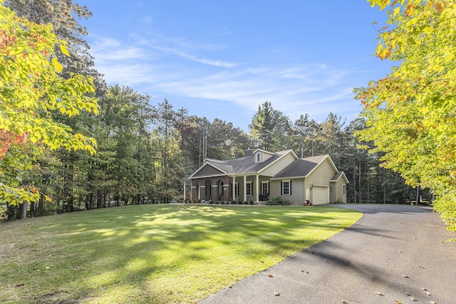 view of front facade featuring a front lawn, a garage, and driveway