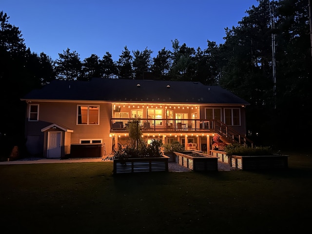 back of property featuring an attached garage, a deck, and stairs