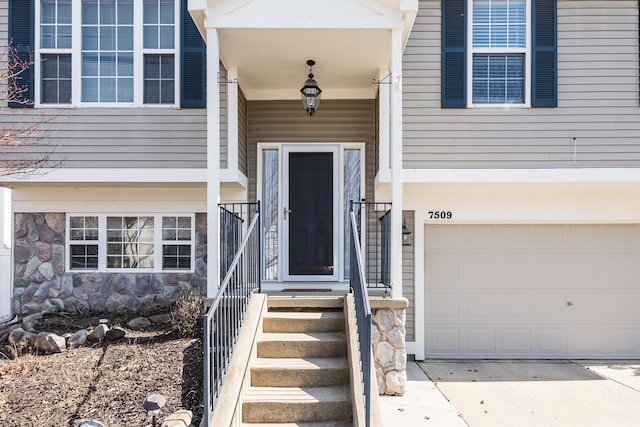 property entrance featuring stone siding and a garage