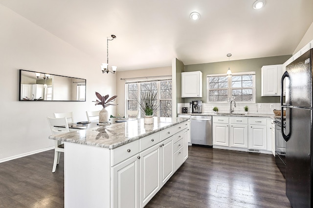 kitchen with a sink, lofted ceiling, plenty of natural light, and dishwasher