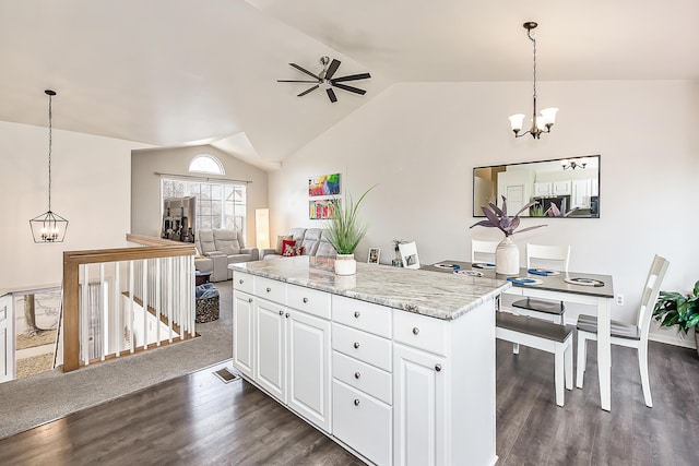 kitchen featuring a center island, vaulted ceiling, an inviting chandelier, white cabinetry, and dark wood-style flooring